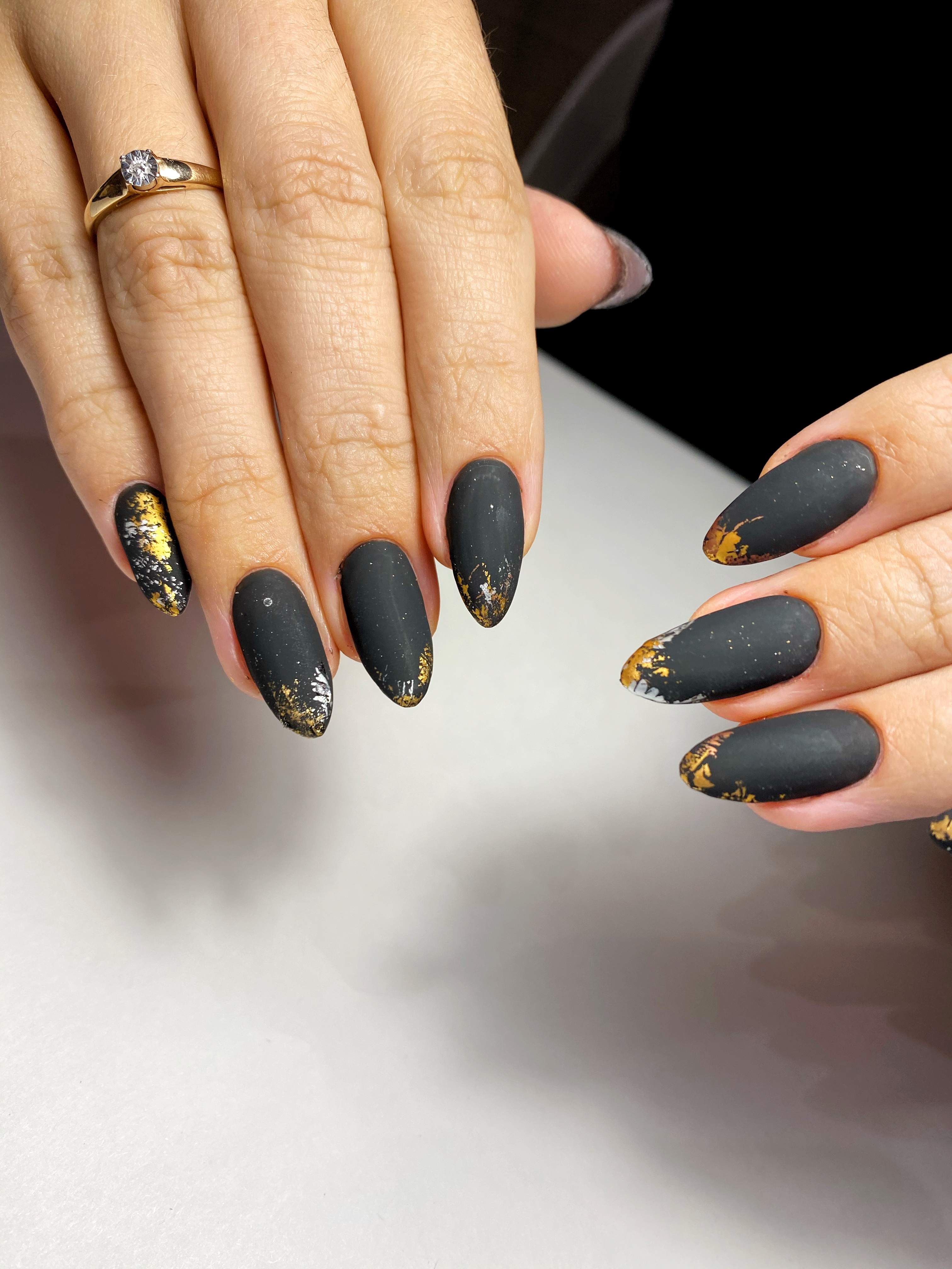 Матовый маникюр с золотой фольгой в черном цвете на длинные ногти.