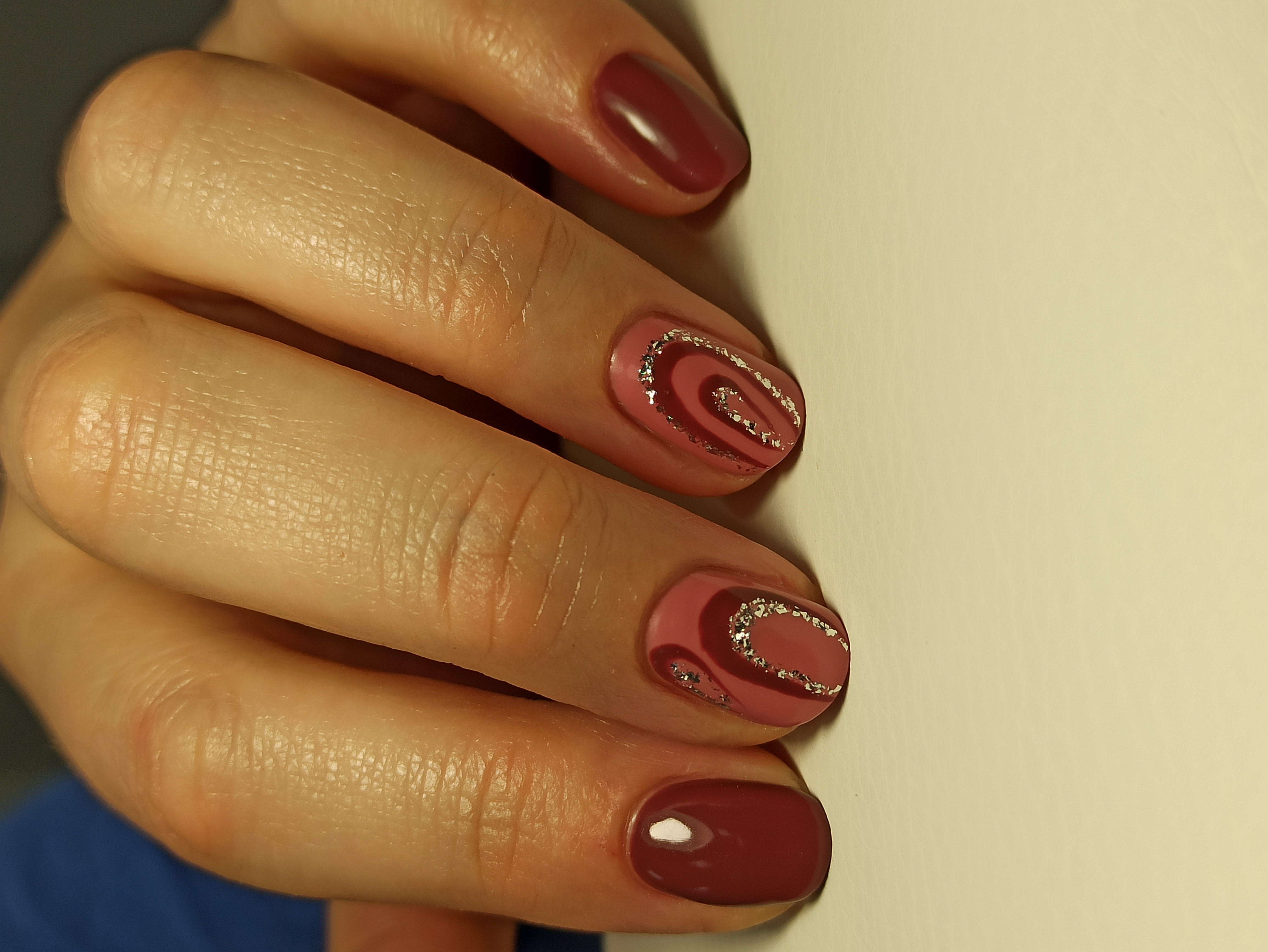 Маникюр с геометрический рисунком и блестками в бордовом цвете на короткие ногти.