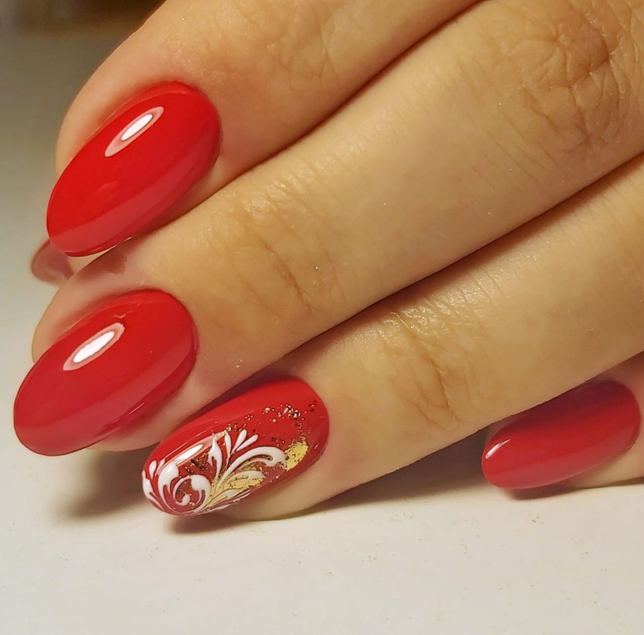 Маникюр с вензелями и золотой фольгой в красном цвете на короткие ногти.