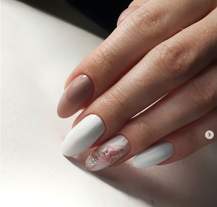 Маникюр с абстрактным рисунком и блестками в белом цвете на длинные ногти.