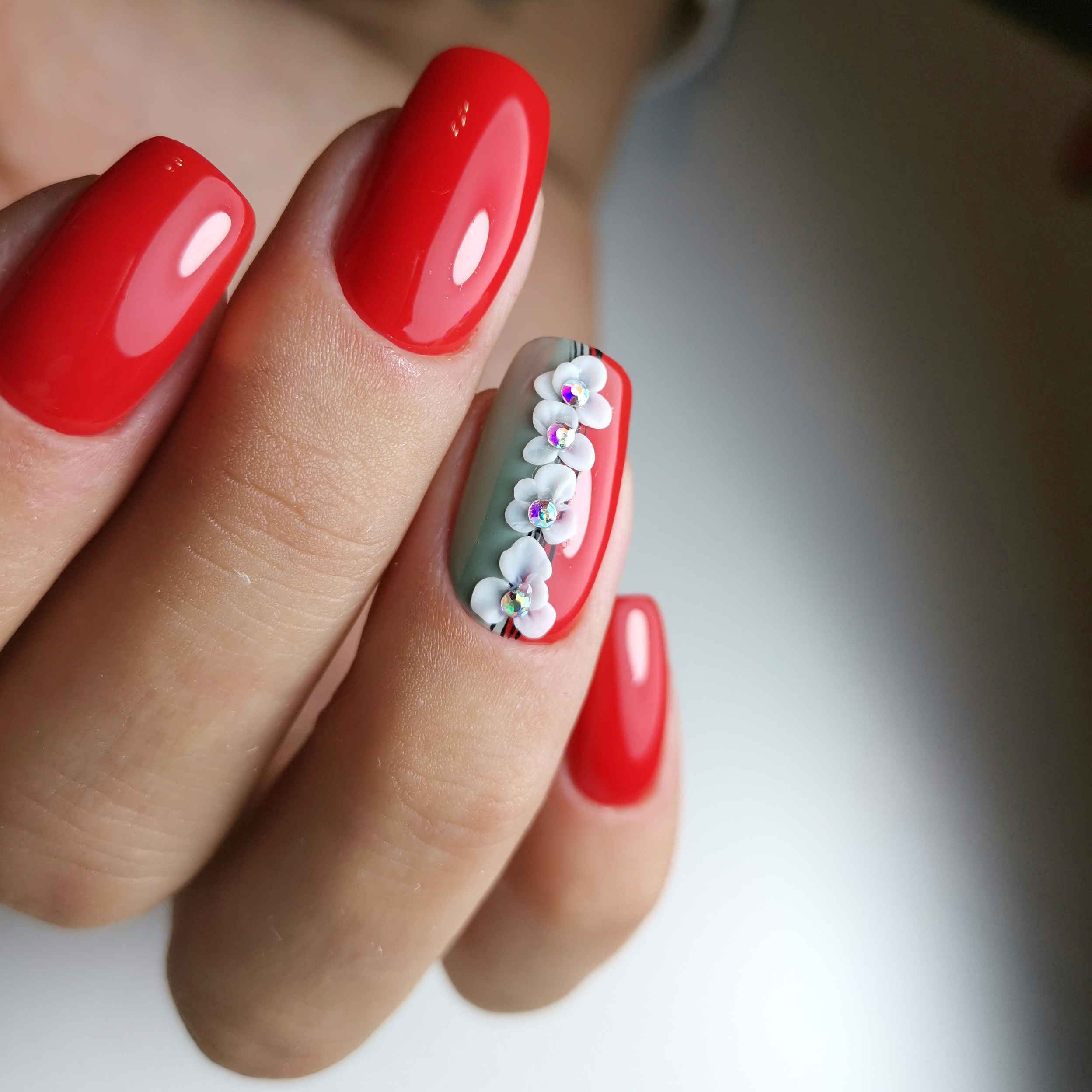 Маникюр с цветочной лепкой в красном цвете на длинные ногти.