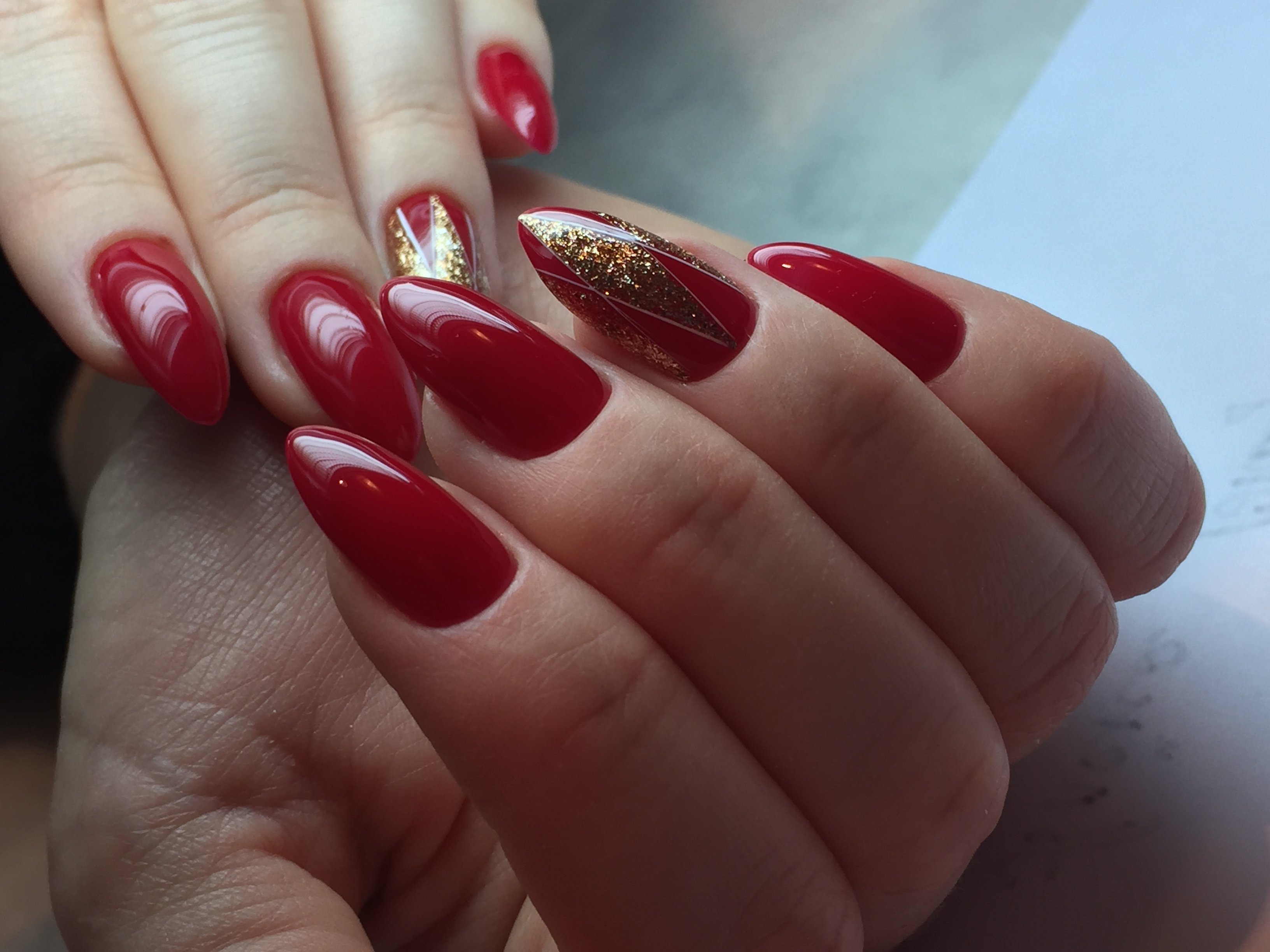Геометрический маникюр с золотыми блестками в красном цвете на длинные ногти.