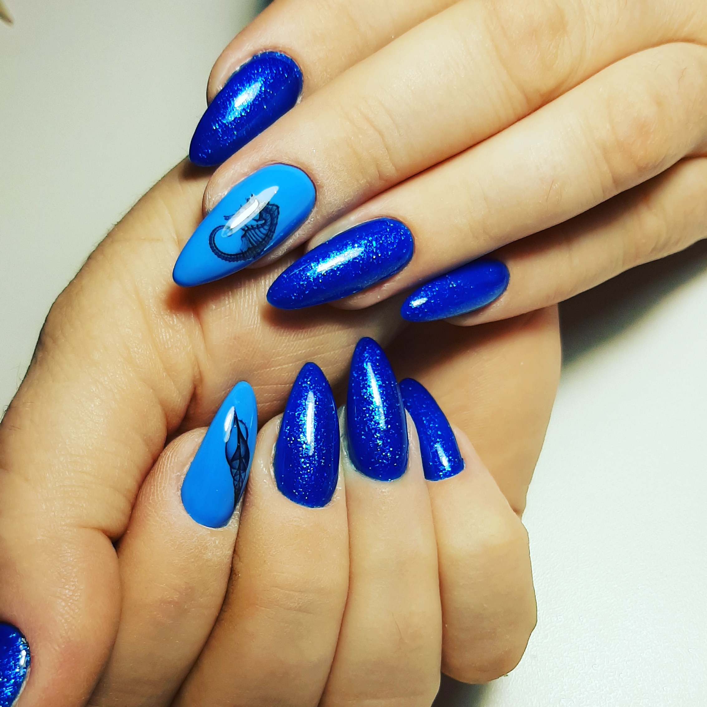 Маникюр со слайдерами и блестками в синем цвете на длинные ногти.
