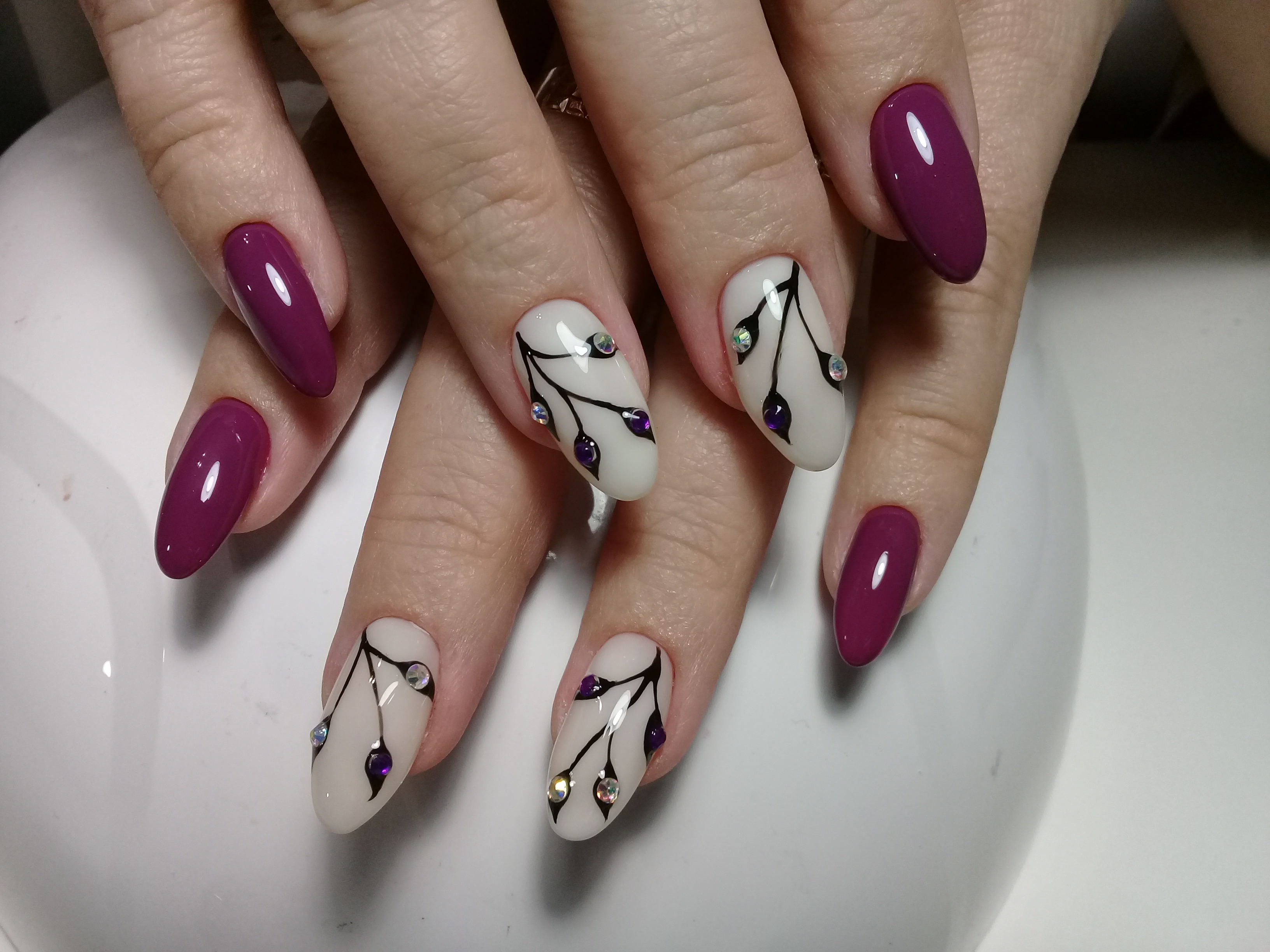 Маникюр с растительным рисунком и стразами в баклажановом цвете на длинные ногти.