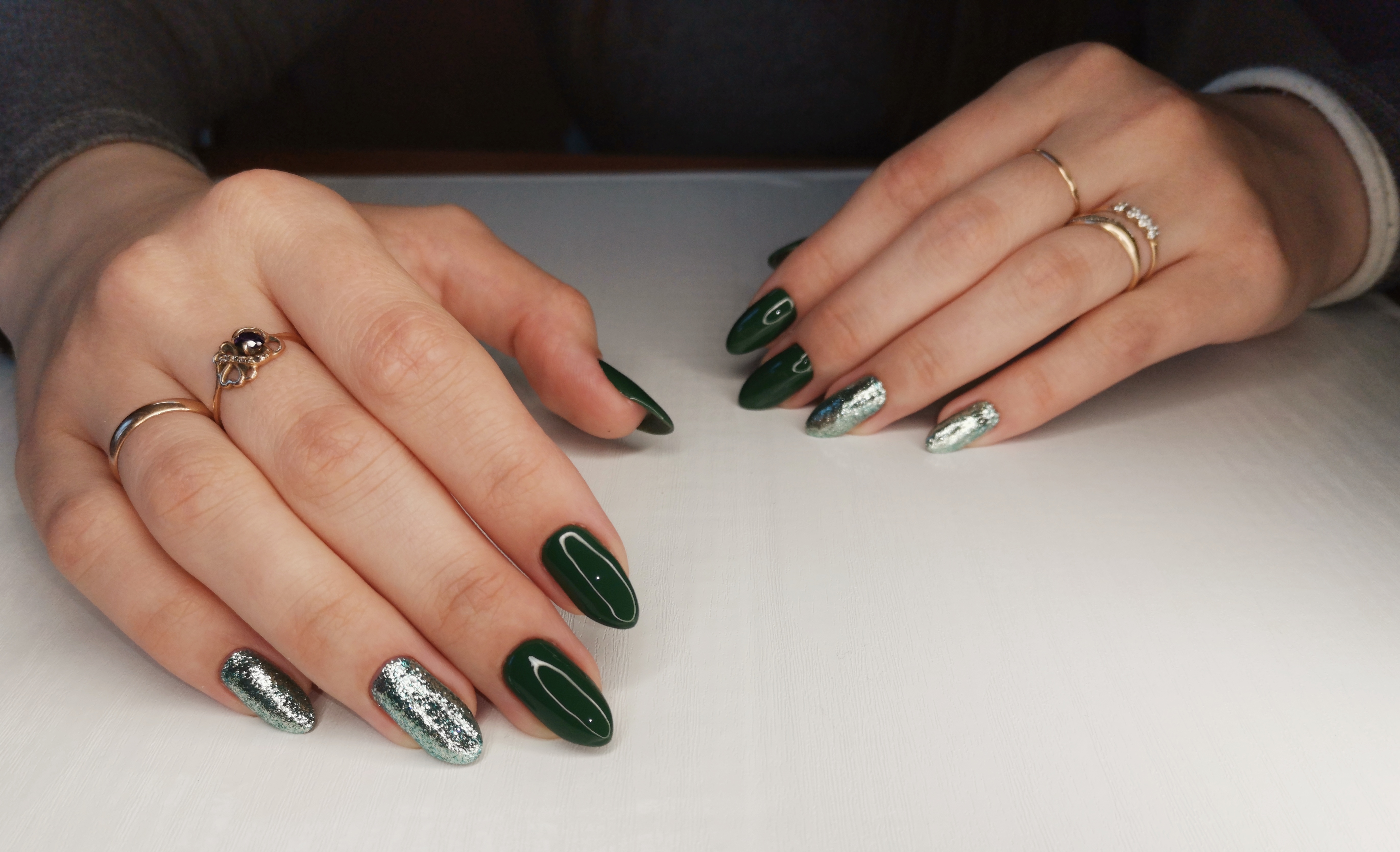 Маникюр с серебряными блестками в темно-зеленом цвете на длинные ногти.