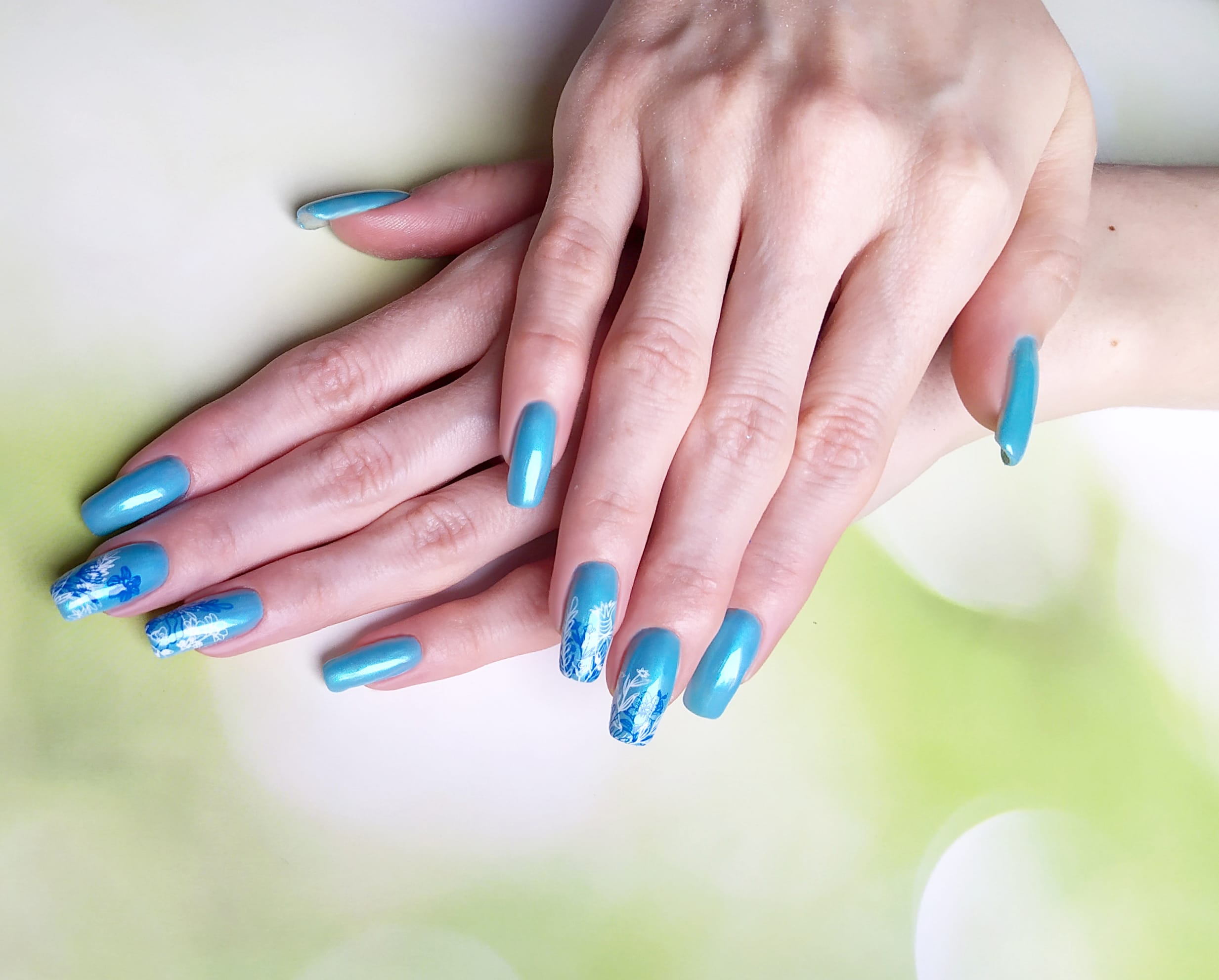Маникюр с растительными слайдерами в голубом цвете на длинные ногти.