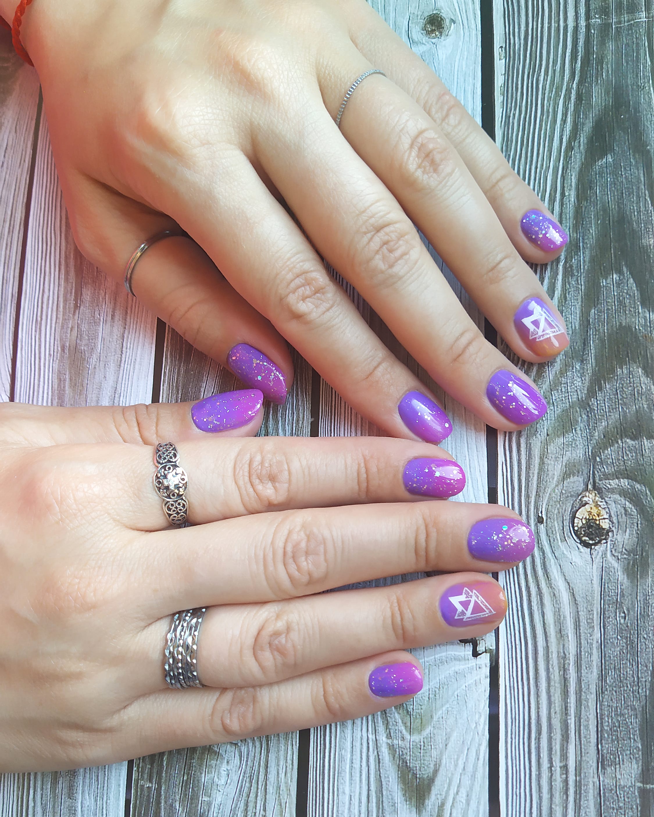 Маникюр с градиентом, блестками и слайдерами в фиолетовом цвете на короткие ногти.