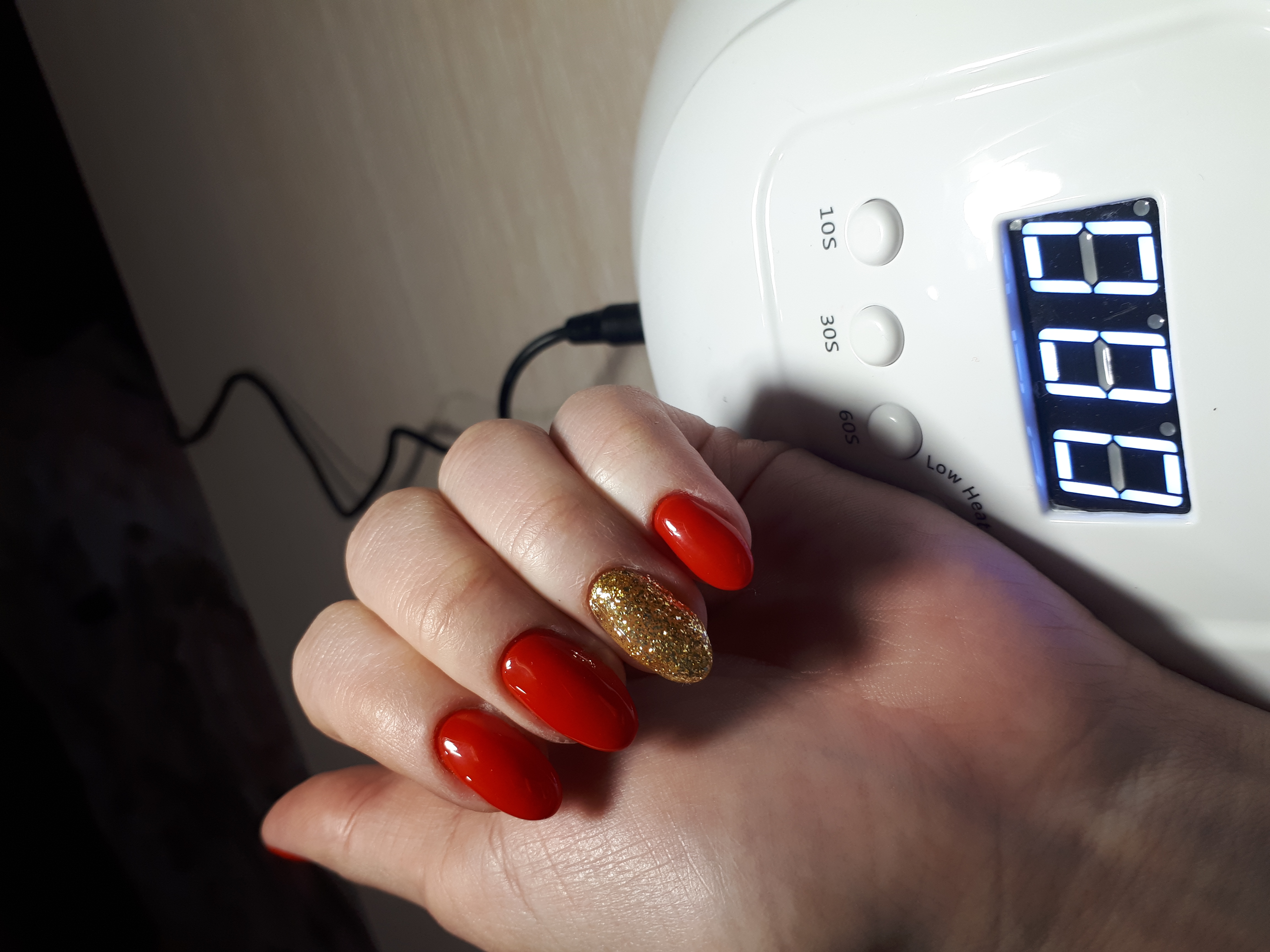 Маникюр с золотыми блестками в  красном цвете на длинные ногти.